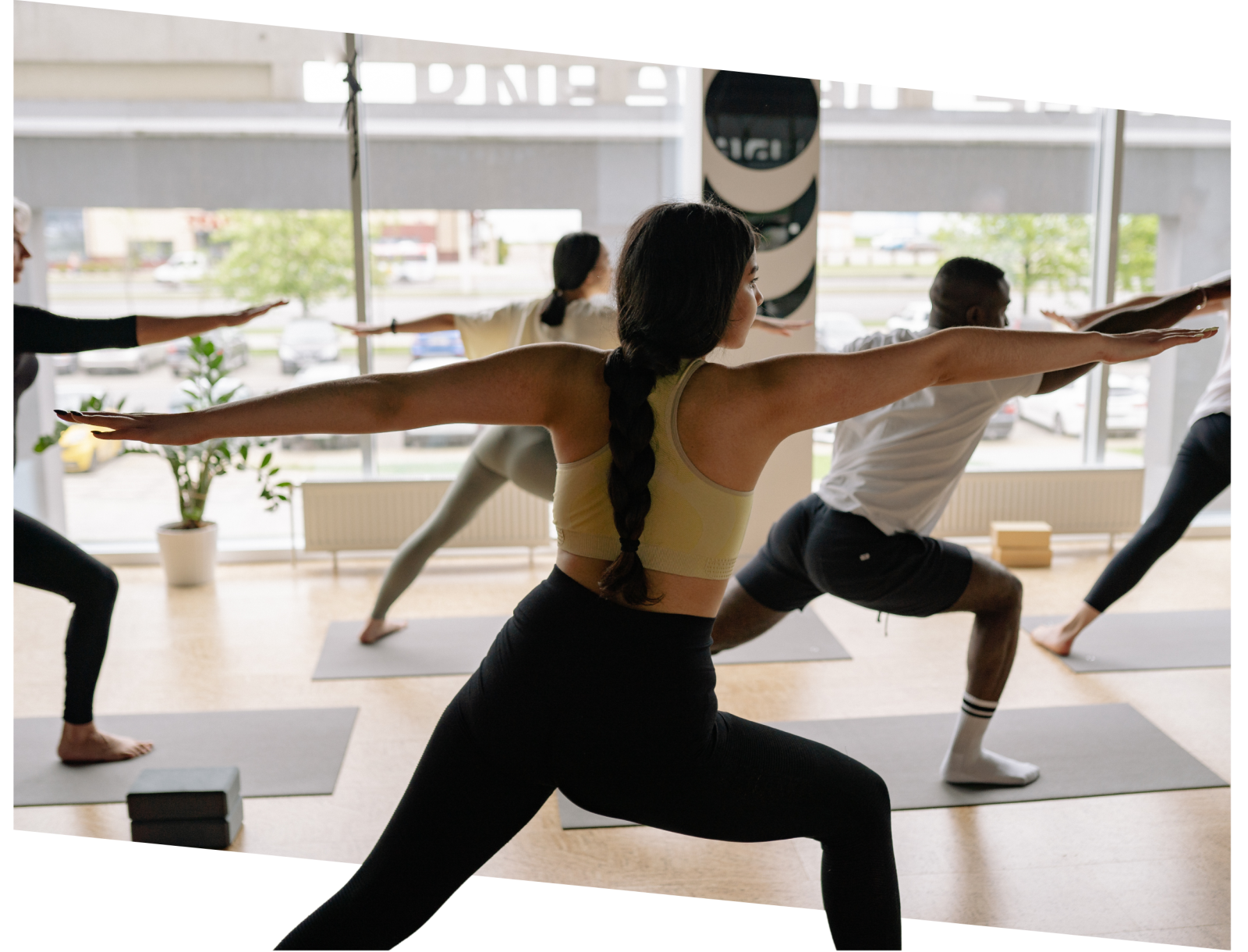 Group of individuals practicing yoga in a bright gym studio, emphasizing fitness and wellness, relevant for gym marketing and SEO services.